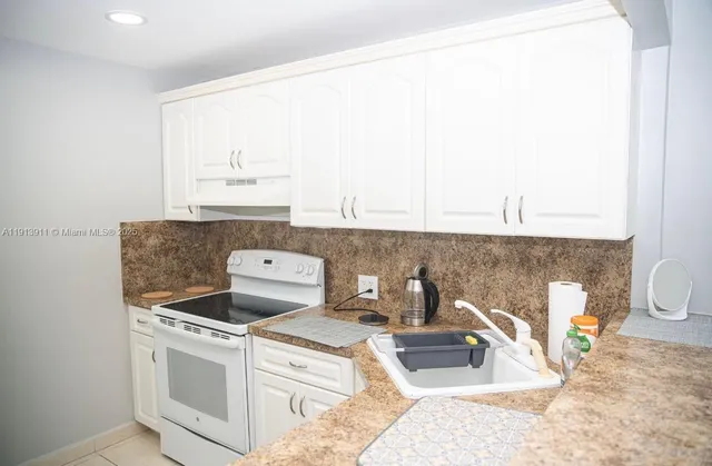 a kitchen with a stove and a white cabinet