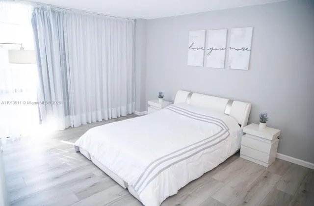 a large bed sitting in a bedroom next to a window