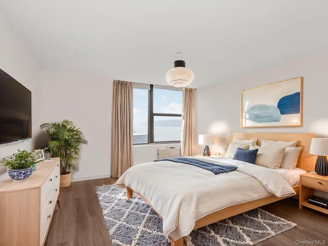 a bedroom with a bed and a potted plant