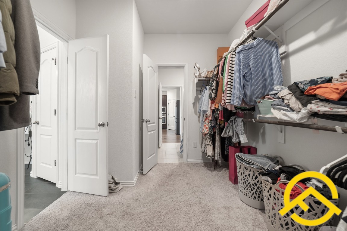 671 Durian Loop Buda, TX 78610 - Photo 23 of 29 a view of walk in closet with clothes and shoes