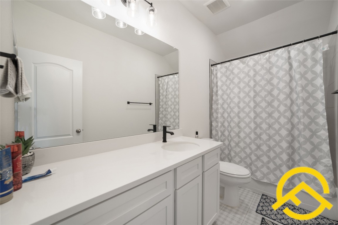 671 Durian Loop Buda, TX 78610 - Photo 24 of 29 a bathroom with a sink a toilet and a mirror