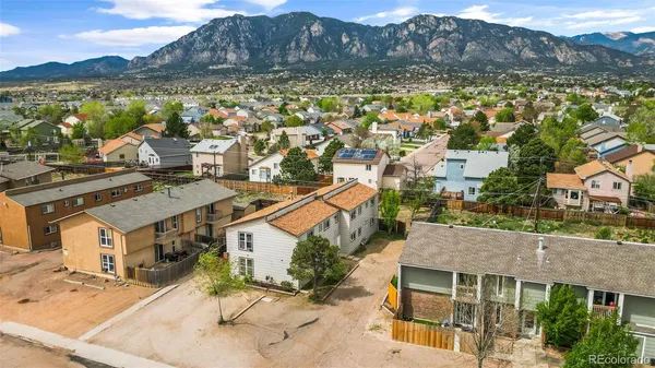 a aerial view of a house with a yard and mountain view in back