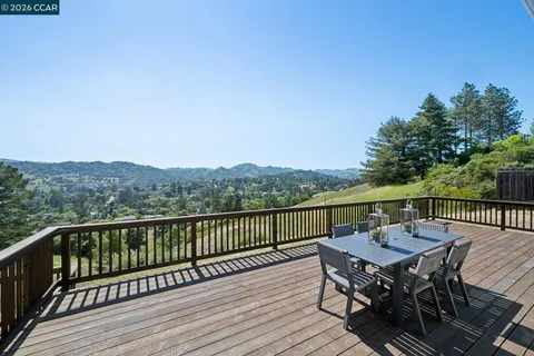 a view of a balcony with wooden floor and outdoor seating