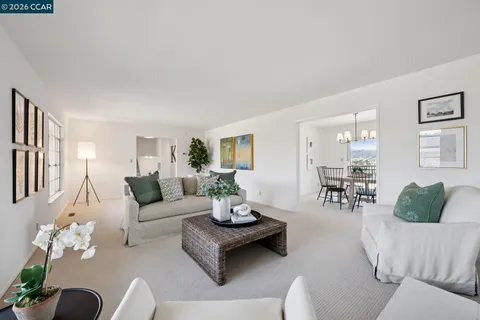 a living room with furniture kitchen view and a window