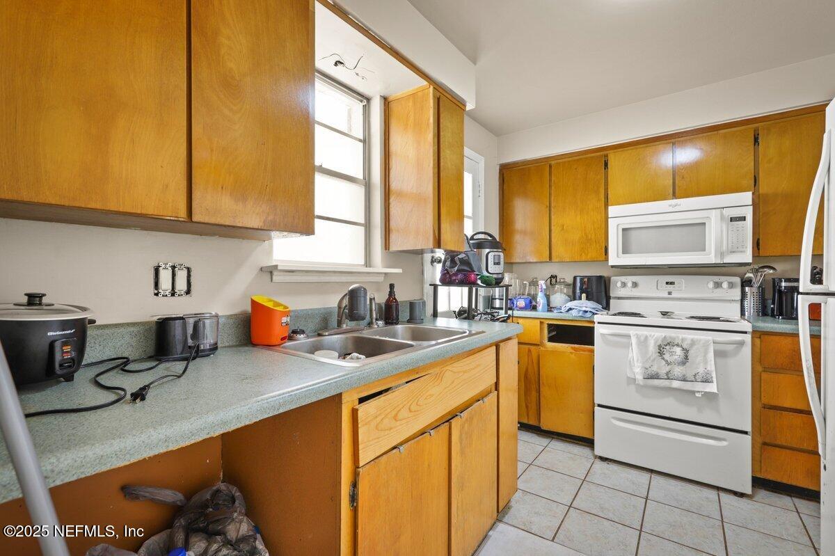 7346 El Barco Road, Unit 7 Jacksonville, FL 32216 - Photo 5 of 6 a kitchen with a sink appliances cabinets and a window