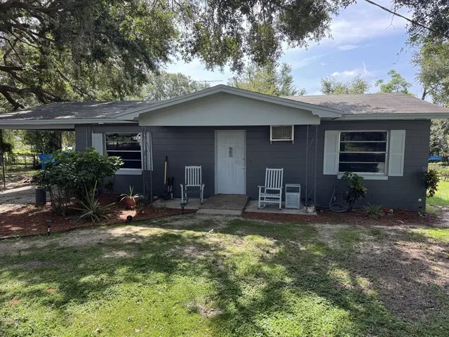 a view of a house with backyard and sitting area