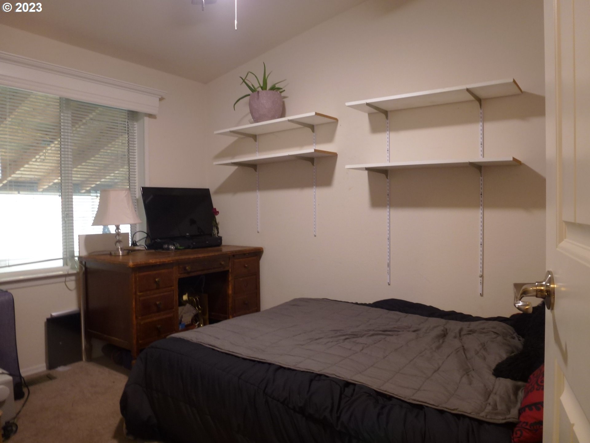 151 Edwards Road South, Unit 87 Monmouth, OR 97361 - Photo 11 of 18 a bedroom with a bed and a flat tv screen on the dresser