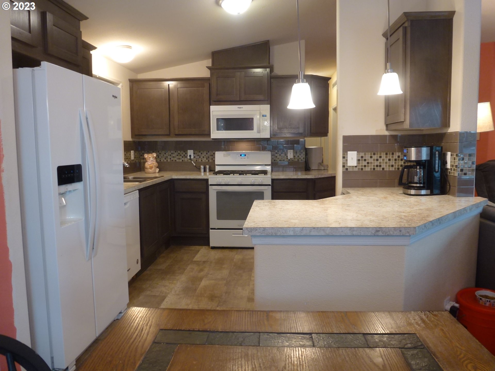 151 Edwards Road South, Unit 87 Monmouth, OR 97361 - Photo 6 of 18 a large kitchen with a refrigerator a stove top oven a sink and dishwasher