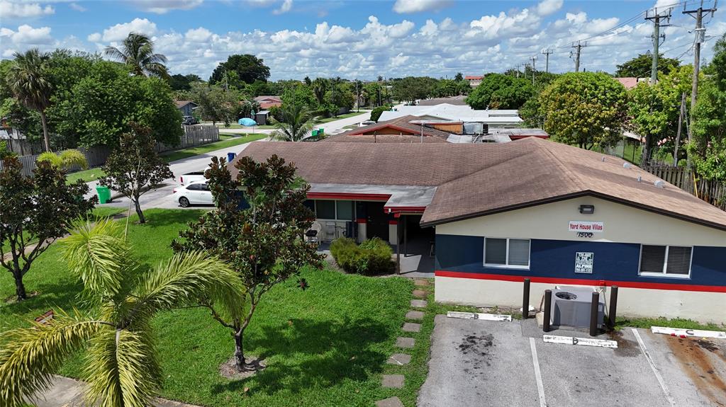a aerial view of a house with a yard plants and large tree