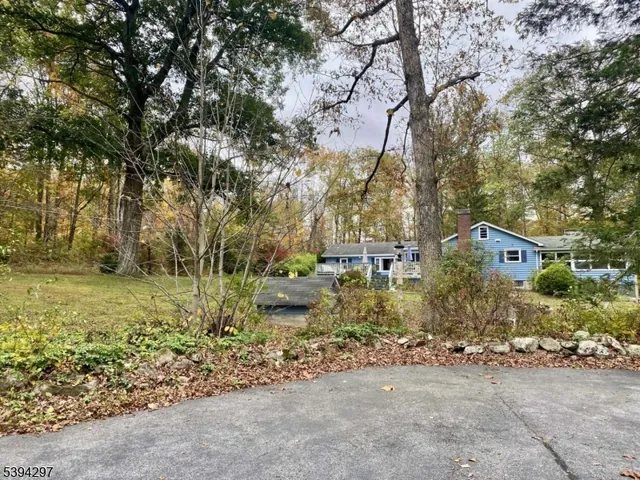 a front view of a house with a yard and mountain view in back