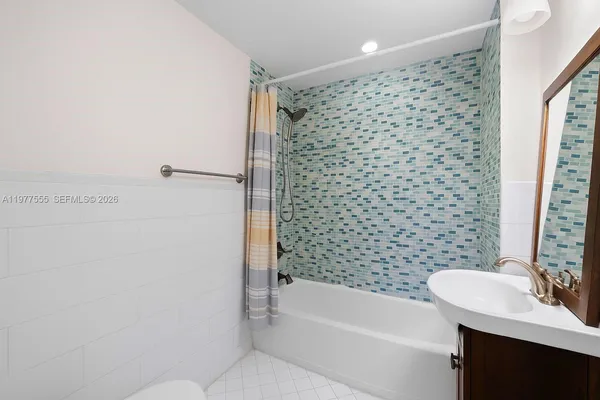 a bathroom with a bathtub a sink a toilet and a shower