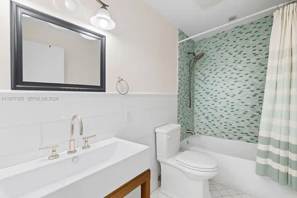 a bathroom with a sink a toilet and shower curtain