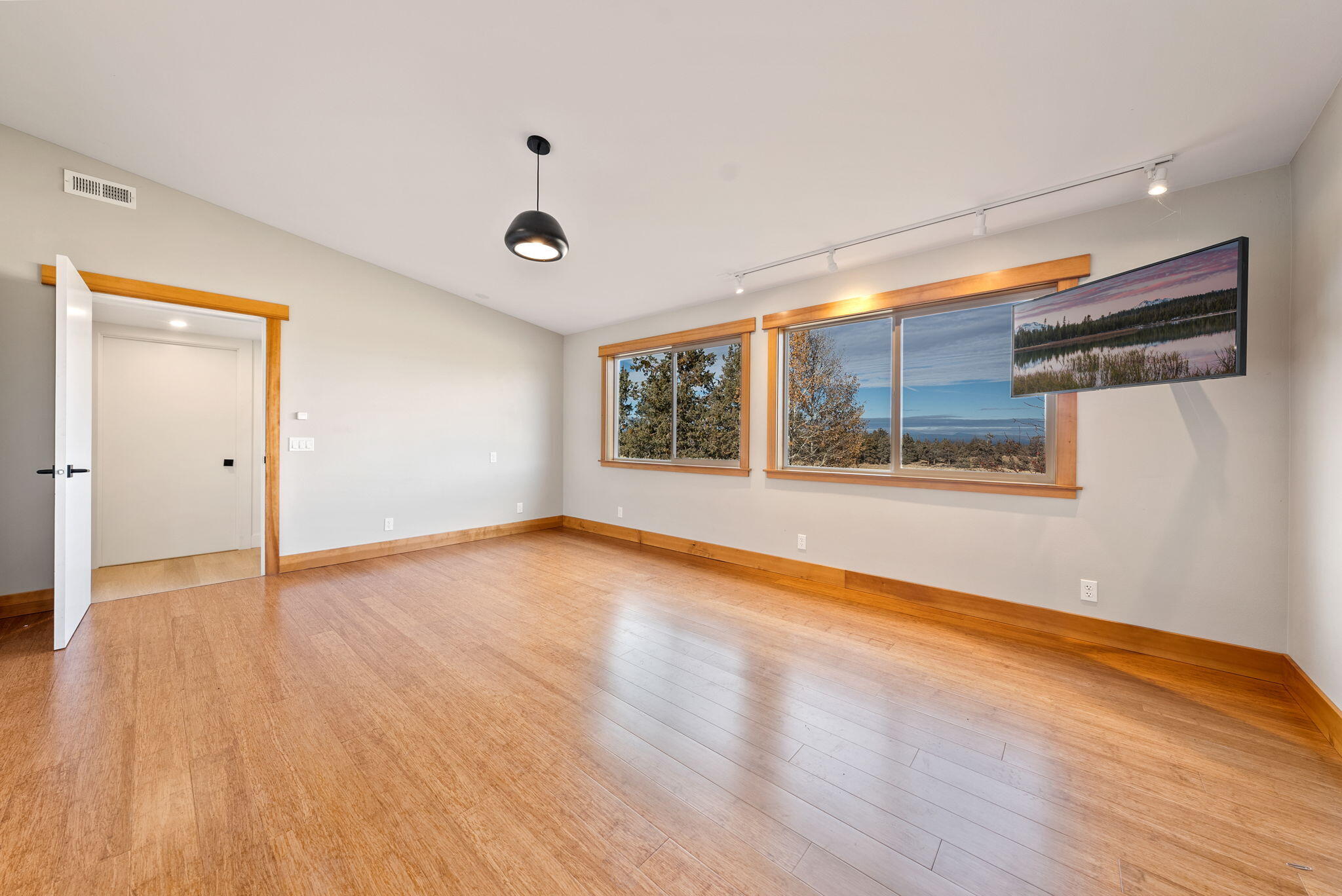 65345 Tweed Road Bend, OR 97703 - Photo 57 of 90 a view of an empty room with wooden floor and a window