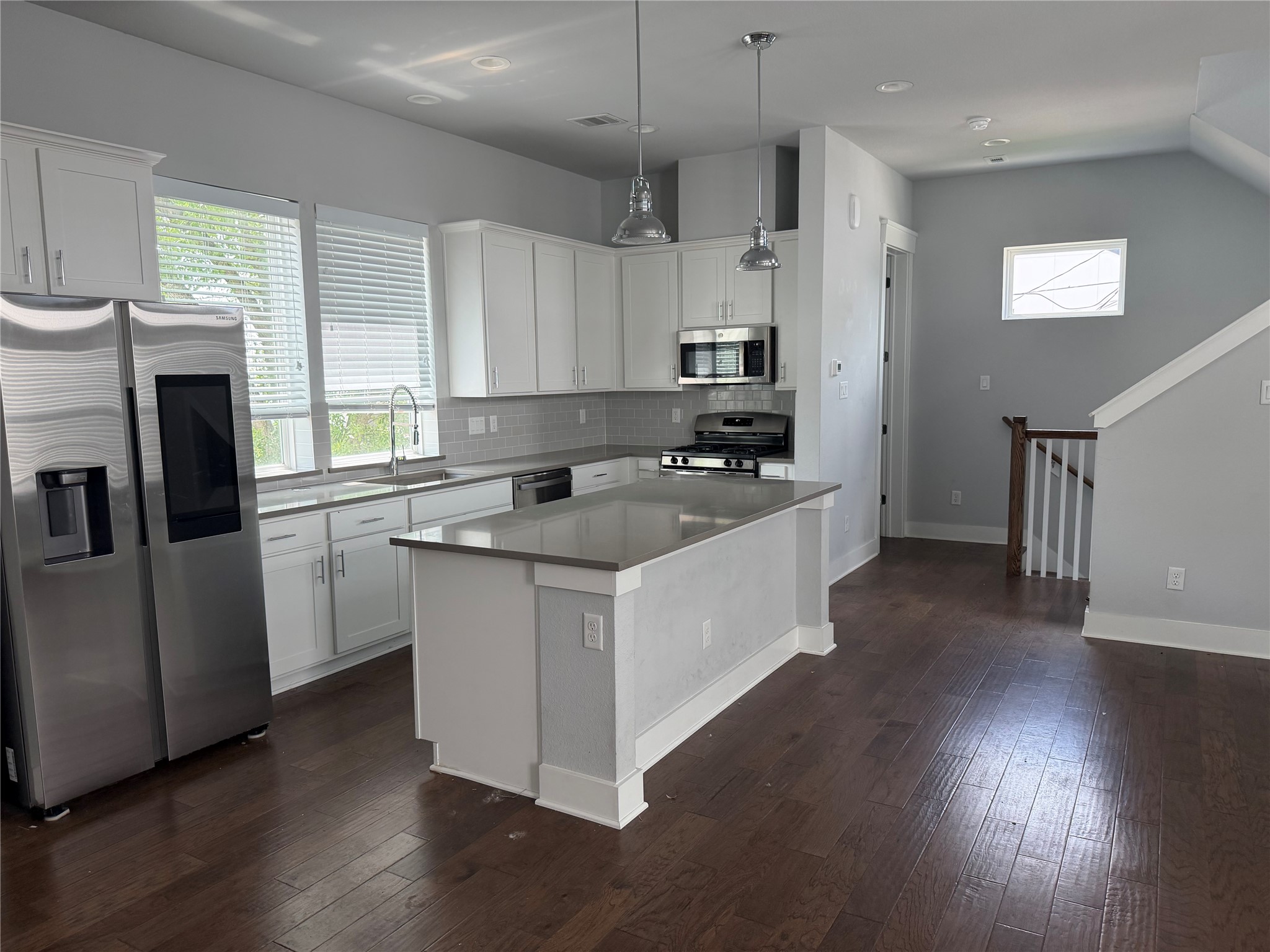 902 Martin Street, Unit A Houston, TX 77018 - Photo 6 of 21 a kitchen with stainless steel appliances a sink a stove a refrigerator cabinets and a wooden floor