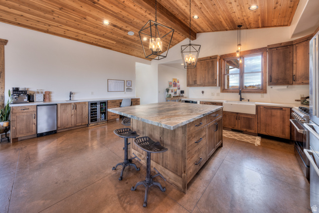 4173 Shadowfax Run, Unit 5 Moab, UT 84532 - Photo 17 of 41 Kitchen featuring Knotty Alder cabinetry, massive center island, wine cooler, concrete flooring, and a breakfast bar