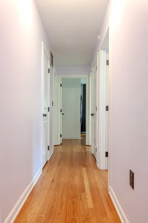 a view of a room with wooden floor and a hallway