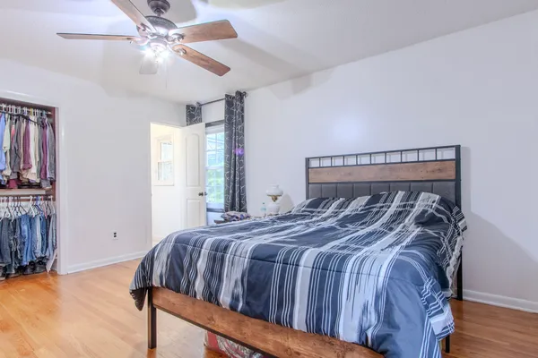 a bedroom with a bed and wooden floor