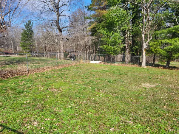 a backyard of a house with lots of green space and fountain