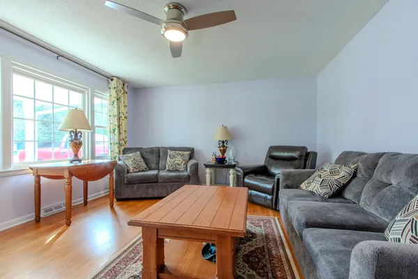 a living room with furniture a flat screen tv and a large window