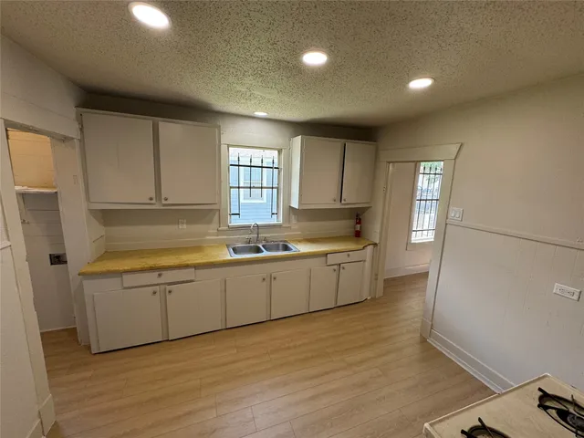 a large kitchen with lot of cabinets and wooden floor