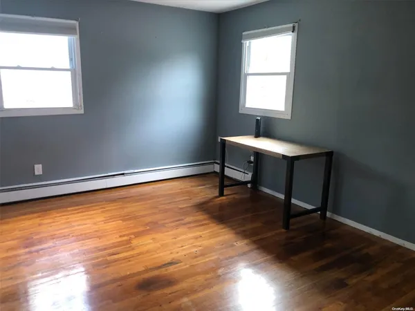 a room with wooden floor a table and a window