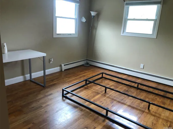 a view of a room with wooden floor and a window