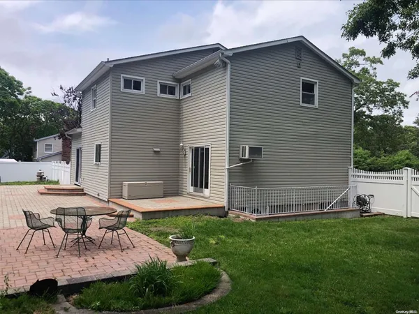 a view of backyard of house with seating space and trampoline