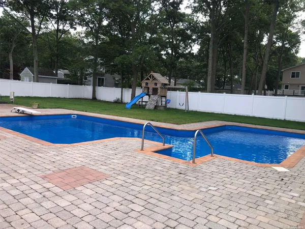 a view of a swimming pool with a yard and trees