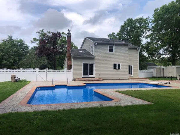 a front view of house with yard and swimming pool