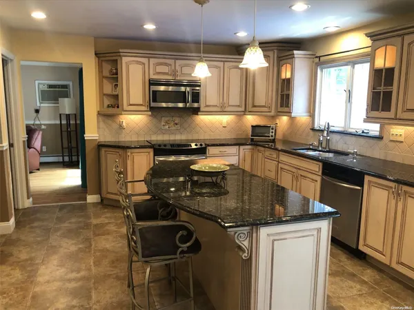 a kitchen with stainless steel appliances granite countertop a sink stove and cabinets