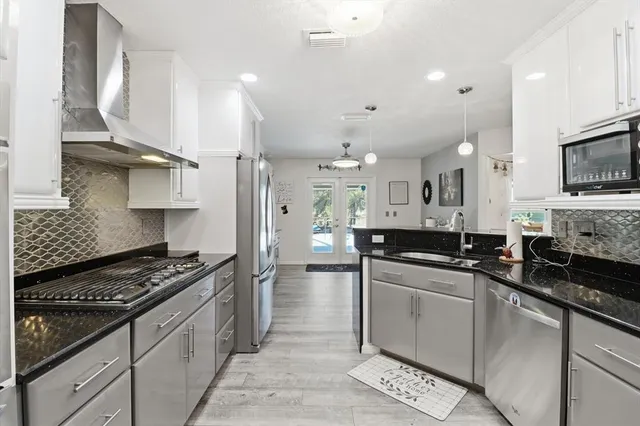 a kitchen with stainless steel appliances a sink stove and cabinets