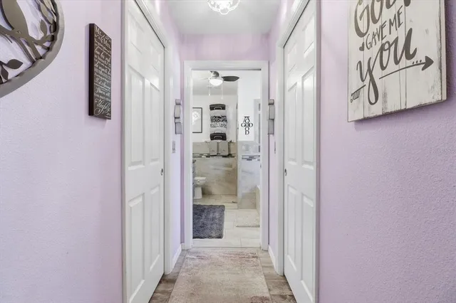 a view of a hallway with wooden floor and a bathroom