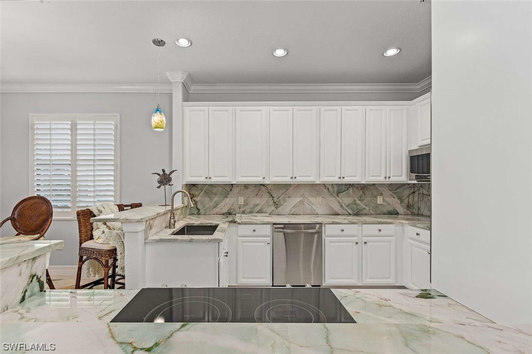 9490 Napoli Lane, Unit 202 Naples, FL 34113 - Photo 12 of 24 a kitchen with a sink and cabinets