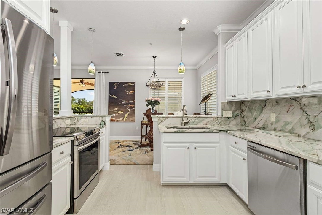 9490 Napoli Lane, Unit 202 Naples, FL 34113 - Photo 13 of 24 a kitchen with stainless steel appliances granite countertop a stove a sink and a refrigerator