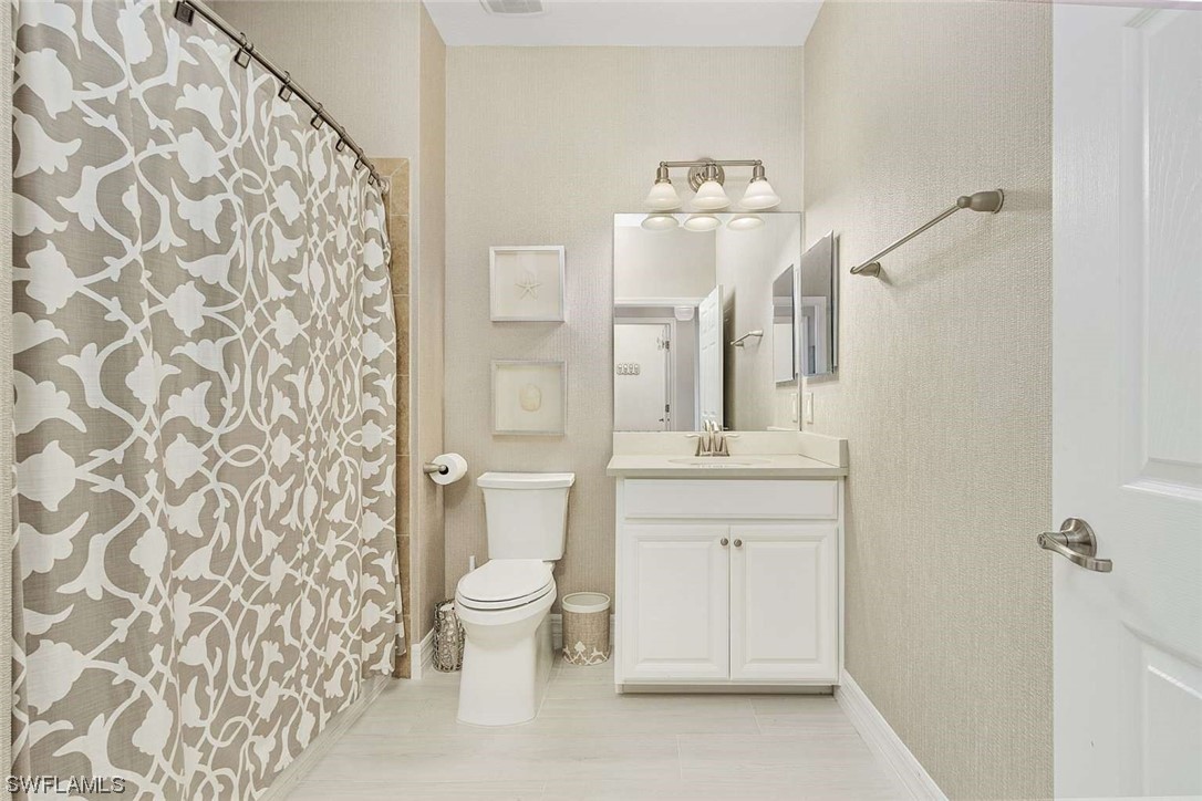 9490 Napoli Lane, Unit 202 Naples, FL 34113 - Photo 5 of 24 a bathroom with a sink a toilet and shower