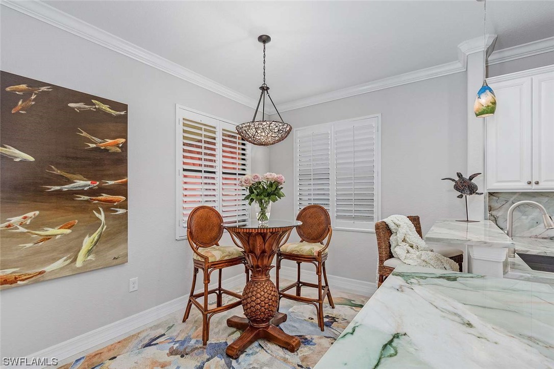 9490 Napoli Lane, Unit 202 Naples, FL 34113 - Photo 9 of 24 a view of a dining room with furniture and chandelier