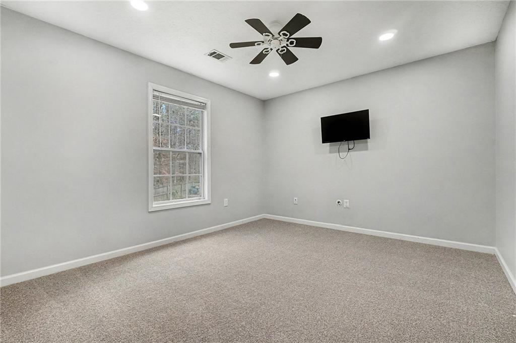 307 Remington Pl Boulevard Dallas, GA 30157 - Photo 12 of 27 an empty room with a flat screen tv and a ceiling fan