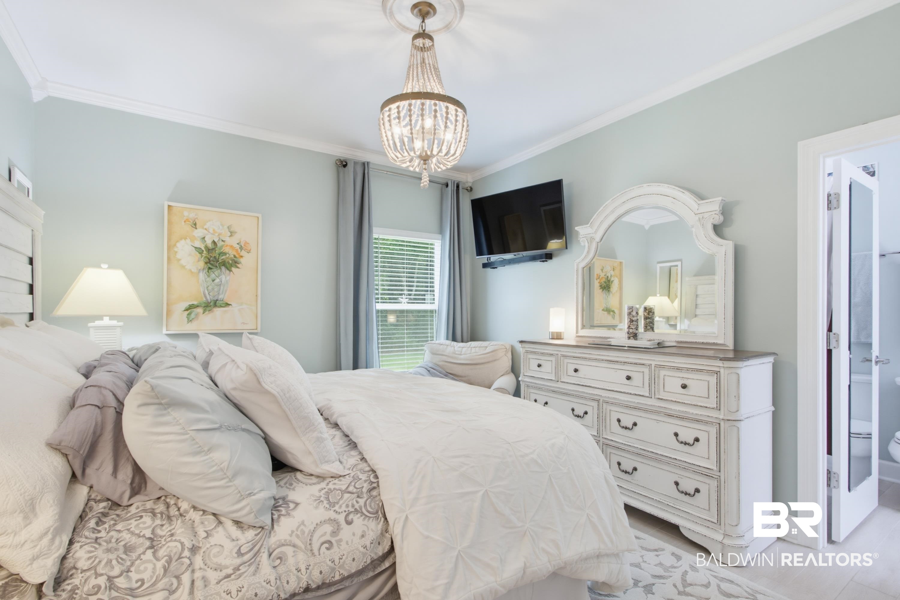7472 Coopers Landing Road Foley, AL 36535 - Photo 22 of 40 Bedroom featuring light blue walls, crown molding, and a decorative ceiling medallion with a crystal chandelier
