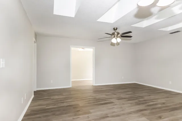 a view of a room with wooden floor and a ceiling fan