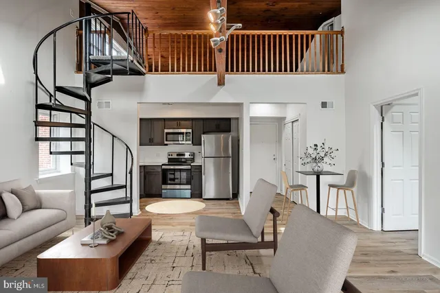 a living room with furniture a fireplace and wooden floor