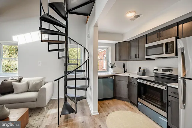 a kitchen with stainless steel appliances kitchen island granite countertop a stove top oven a sink and dishwasher