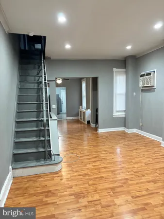 a view of an empty room with a chandelier fan