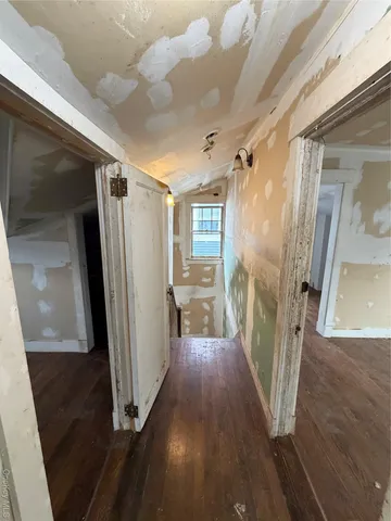 a view of a hallway with wooden floor and staircase
