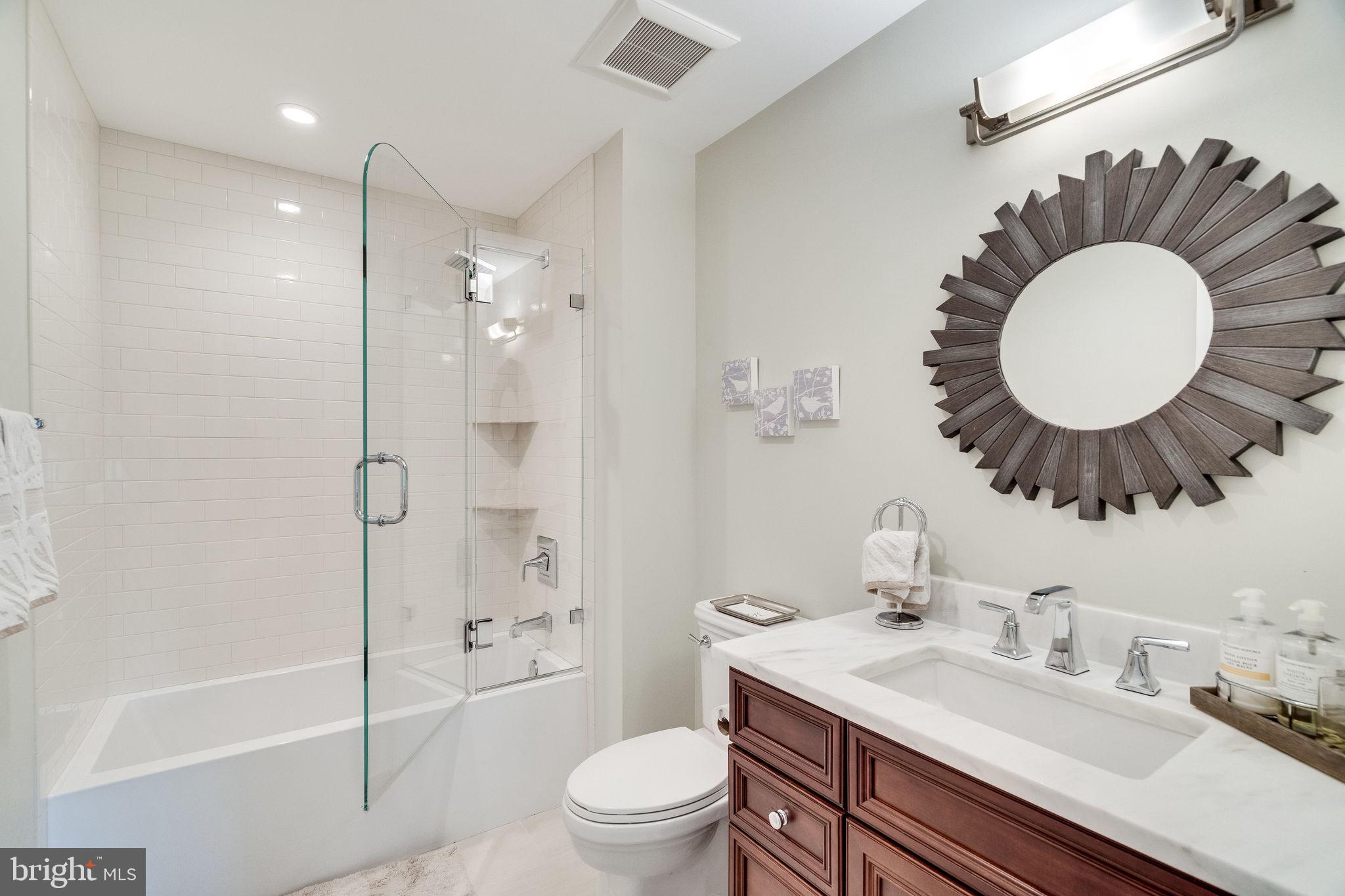 6221 Arkendale Road Alexandria, VA 22307 - Photo 40 of 60 a bathroom with a toilet a sink a tub and mirror