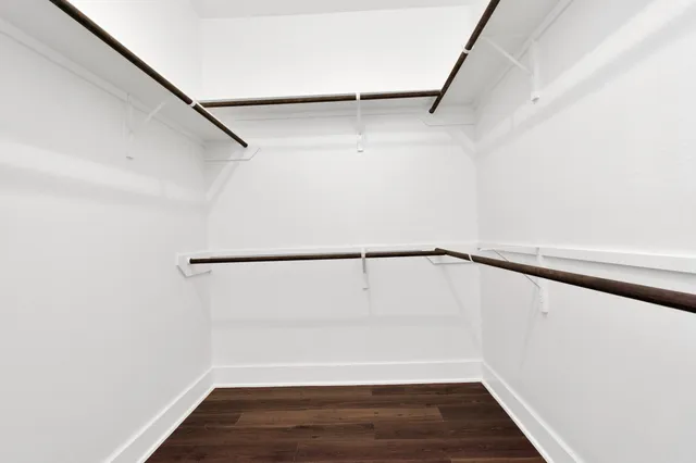 a view of walk in closet with wooden floor