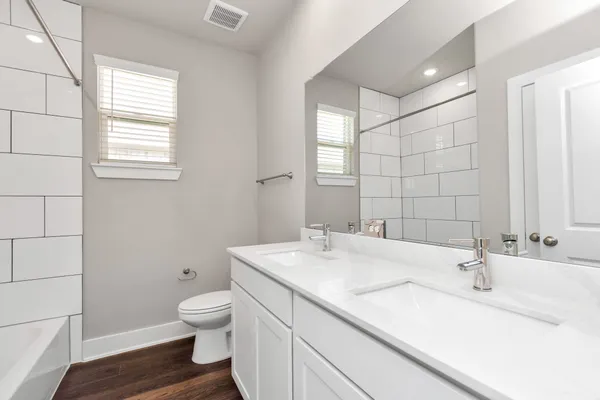 a bathroom with a granite countertop sink a toilet and a mirror
