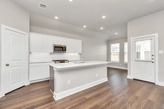 a kitchen with stainless steel appliances a stove top oven and a refrigerator
