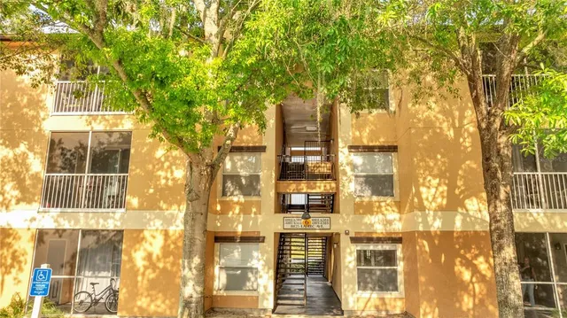 a view of a brick house with a large tree