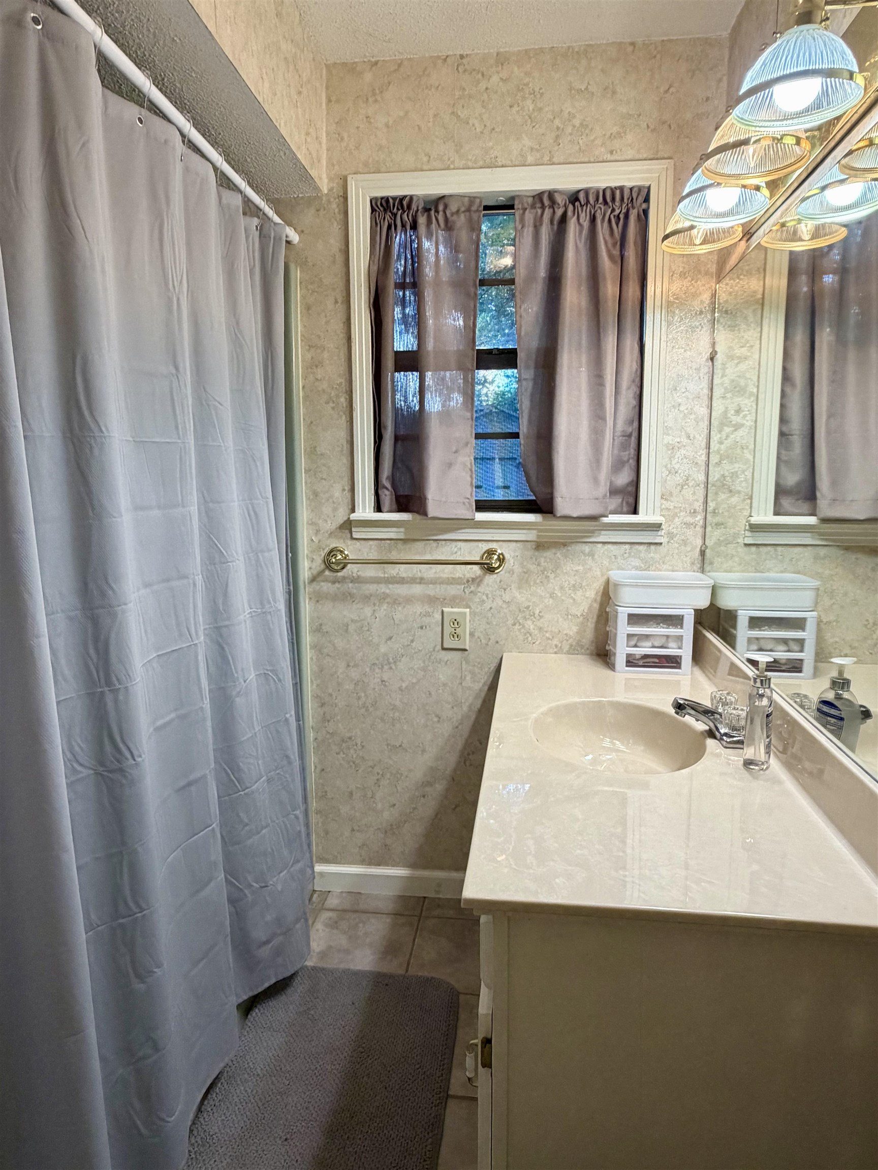 373 Clarence Barham Road Bethel Springs, TN 38315 - Photo 17 of 28 Bathroom featuring a single vanity with an integrated sink, polished chrome faucet, and a large wall mirror