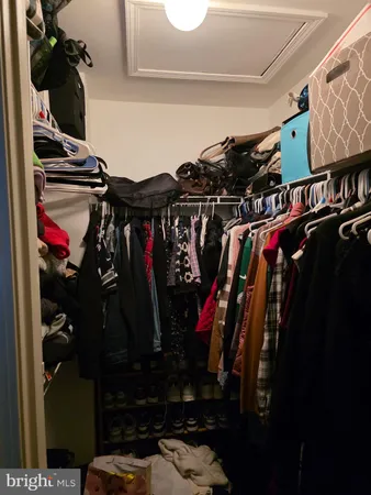 a view of walk in closet with clothes and shoes